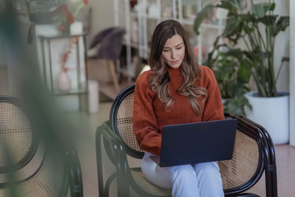 Startup founder reviewing marketing strategy options on a laptop before hiring help